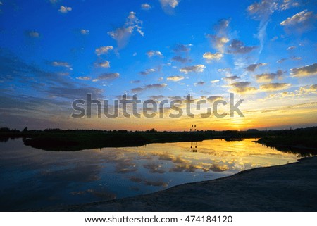 Clouds reflected in river water at sunset. Summer landscape.