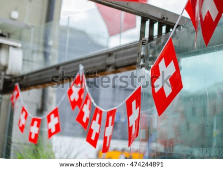 National day in Switzerland. Swiss flags hang in a row outdoor. Soft focus blurry background space for your text. Photo taken on Swiss National Day in Bern, Switzerland.