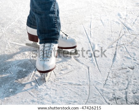 Legs of skater on winter ice rink in outdoors
