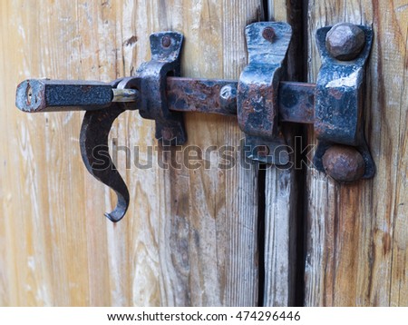 Old latch of a wooden door of a cow shed
