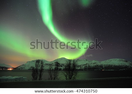 Northern lights over the hills and fjord near Tromso, Northern Norway.