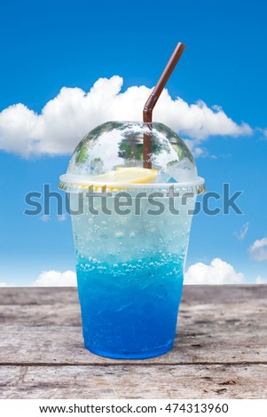 blue lemon soda on wooden table with blue sky background