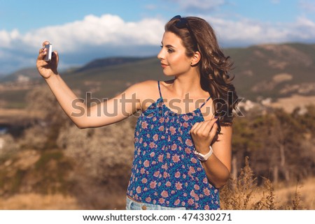 Pretty teen girl taking photo by phone
