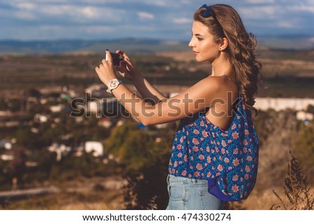 Pretty teen girl taking picture by phone