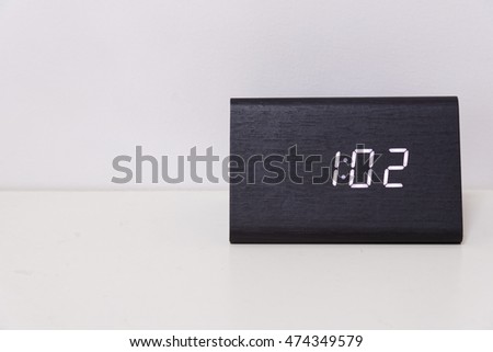 Black digital clock on a white background showing time 1:02 (one hour two minutes)