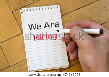 We are hiring text concept on notebook over wooden background