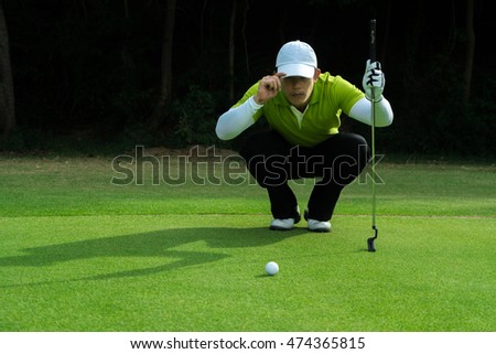 Golfer putt golf ball on the green golf. focus line on green.