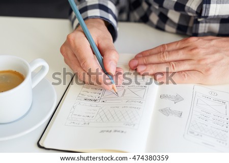 Man draws a sketch graphic design for website
