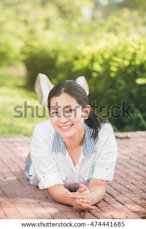 Young asian woman relaxing outdoors looking happy and smiling