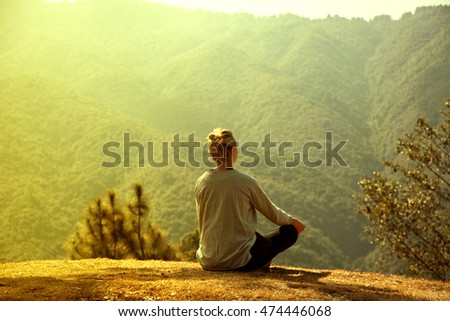 Girl meditates in mountains