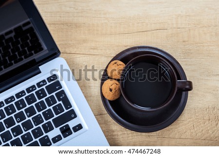 Cup of coffee and a laptop on a office table