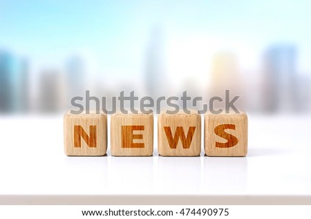 Wooden cubes message word news on white table city view.Advertisement design concept.Morning daily news symbol.