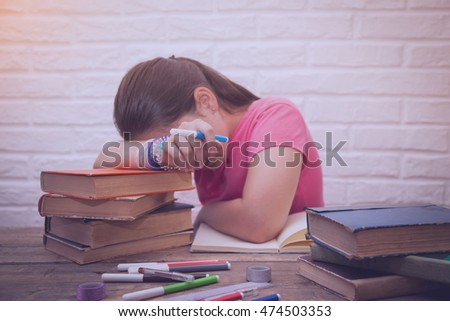 Girl is tired of reading books, decided to relax with his head resting on books