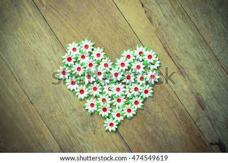 Paper flowers arranged into character in heart shape. Vintage tone background. Can use for card design , advertising , wedding card, background etc.