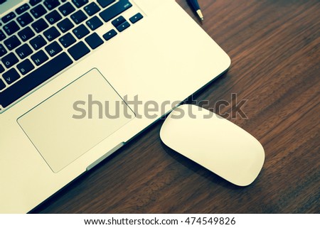 Wireless mouse and laptop keyboard on wood background.Technology concept.