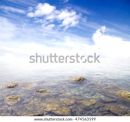 rocky entrance to the sea on a background of blue sky with clouds