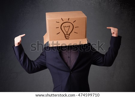 Young man standing and gesturing with a cardboard box on his head with light bulb