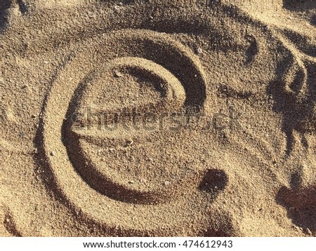 Alphabet's letter E handwritten in sand on the beach