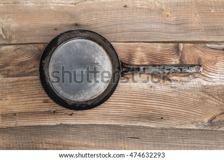 Metal frying pan on the vintage background