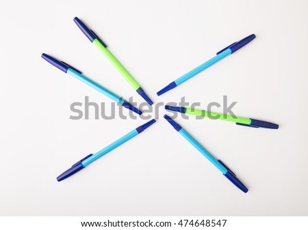 ballpoint pens of different colors on a white background.