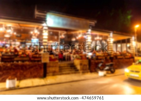 Interior of small restaurant blurred background. Blurred bokeh cafe interior in warm dark colors. Background for creative fashion design. Restaurant, coffee shop with beautiful background blur bokeh