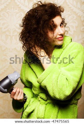   Beautiful woman drying her hair with hairdryer