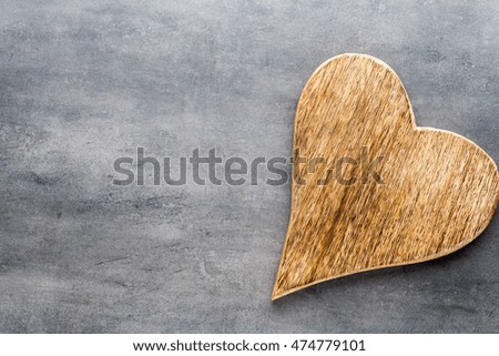 Wooden rustic heart on the grey background.