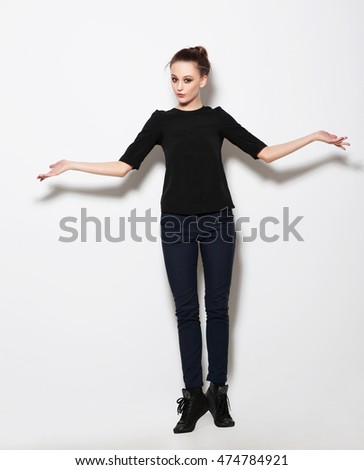 Young girl model posing in the studio full-length. Hands to the side.