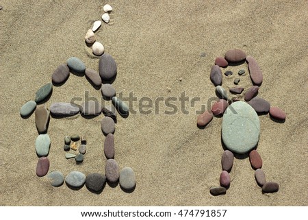 Man and house from pebble on sand background