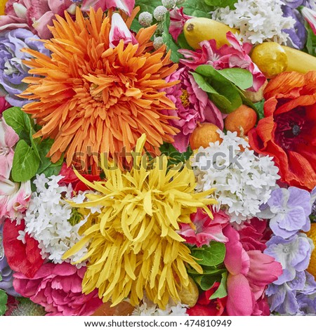 fake orange and yellow flowers closeup, colorful background