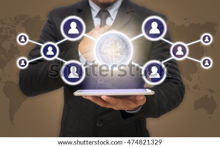 Businessman holding the tablet with the Social media symbol on ice coffee color background with world map,Elements of this image furnished by NASA, Business network concept