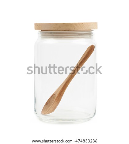 Glass kitchen jar with a round wooden cap and spoon inside, composition isolated over the white background