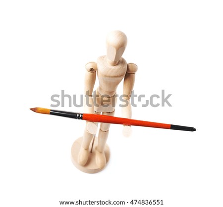 Wooden human statuette holding a drawing brush, composition isolated over the white background