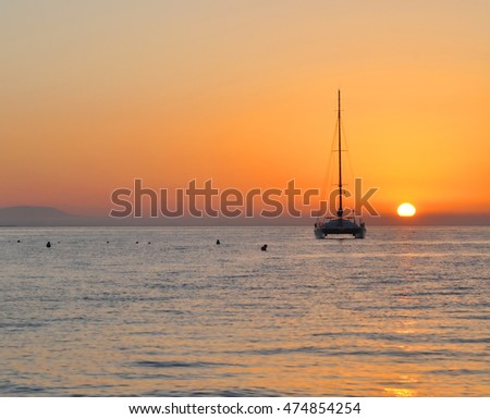 Sailing catamaran at the ocean at sunrise.