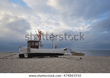 Traditional german fishing boat on the beach of Baltic sea in the sunset before storm. Picture taken in East Germany on the Usedom island in the evening in summer, waiting for morning to fish herings.