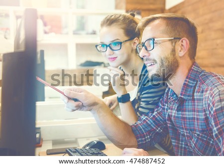 Two colleagues working together on an innovative product design in a creative studio. Young Casual business couple using computer in the office. Coworking, Creative manager showing new startup idea