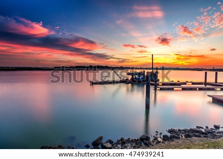 Beautiful long exposure sunrise shot at jetty with a reflection. Image contain certain grain or noise and soft focus when view at full resolution