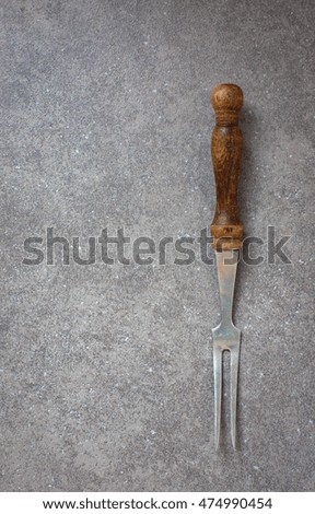 Dark background. Antique utensil . Meat fork 