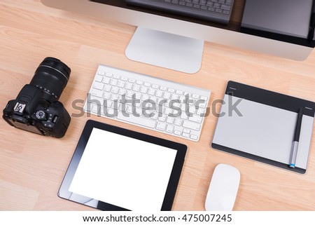 DSLR digital camera with tablet and computer PC on wooden dask table