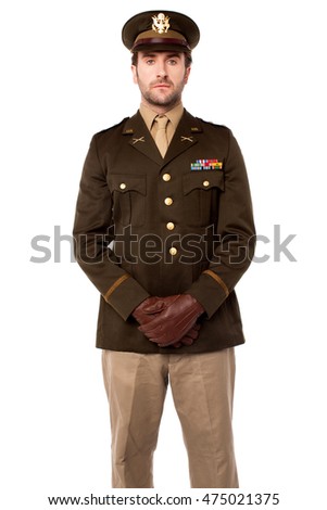 Confident serviceman in uniform posing against white background