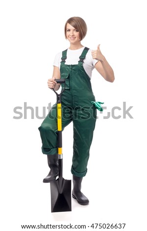 attractive young woman professional gardener in workwear with shovel making thumb up gesture isolated on white background. gardening and business concept. proposing service. advertisement gesture