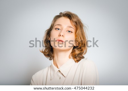 beautiful girl is proud of herself, close-up, isolated on a gray background