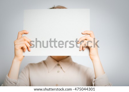 beautiful girl holding a sheet of paper for your text, close-up, isolated on a gray background
