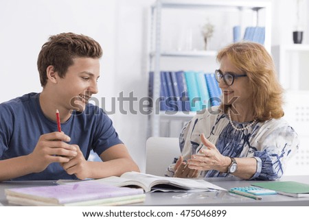 Mature teacher giving private lessons to a teenage boy Royalty-Free Stock Photo #475046899