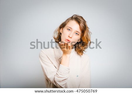 Beautiful girl send blow a kiss, closeup, isolated on a gray background