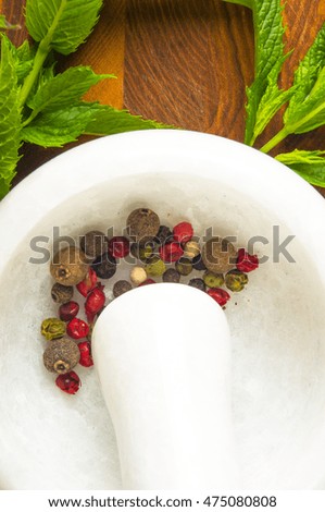 Fresh spearmint herb Mentha in the marble mortar with a pestle with spices, on a wooden background