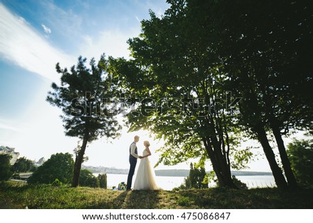 bride groom standing in the park and tenderly looking at each other
