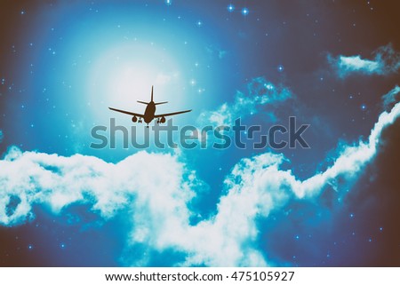 Silhouette of an airplane on a starry sky with clouds.