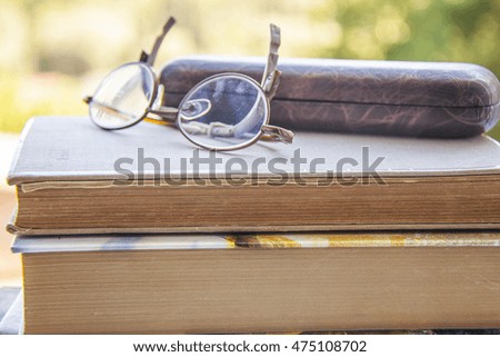 Stack of books with a pair of glasses