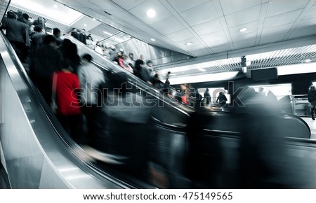 business people rushing on the escalator in motion blur on the subway station. Royalty-Free Stock Photo #475149565